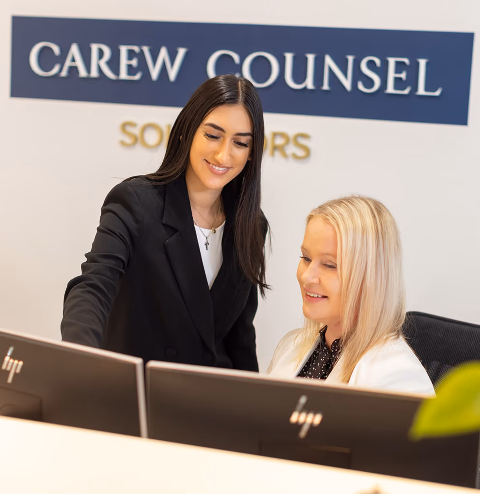 Two of our probate lawyers chatting at a desk in our Melbourne offices.