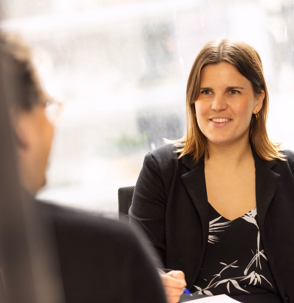 One of our lawyers smiling and chatting with a client in our Melbourne offices.