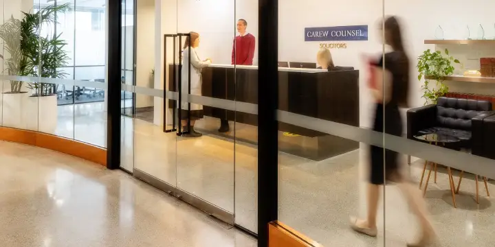 Reception area of Carew Counsel Solicitors with staff assisting a visitor.