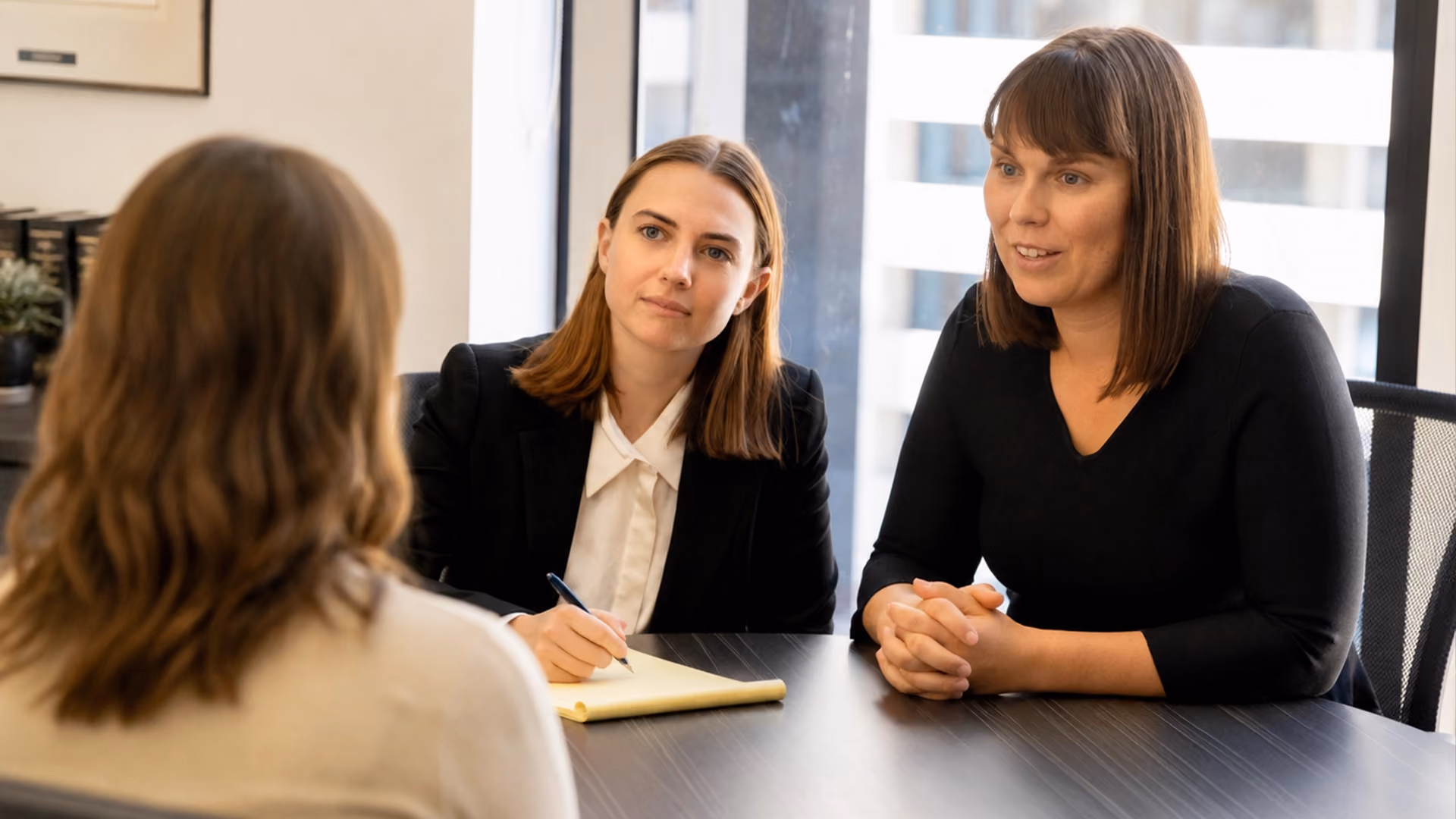 Client speaking with family lawyers in a professional office setting.