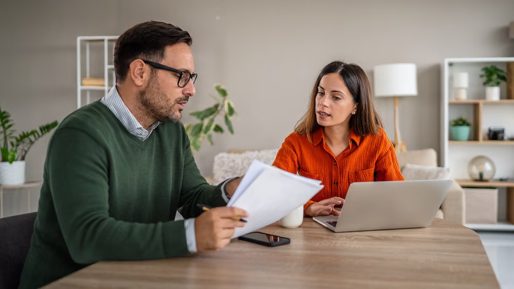Couple reviewing financial planning documents related to a financial agreement.