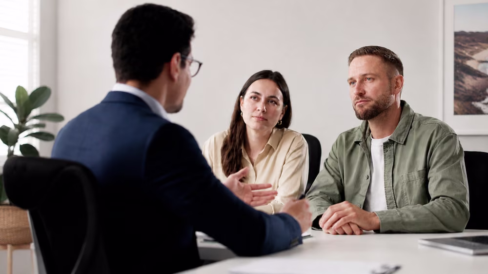 Couple discussing financial agreement planning with a family lawyer in Australia.
