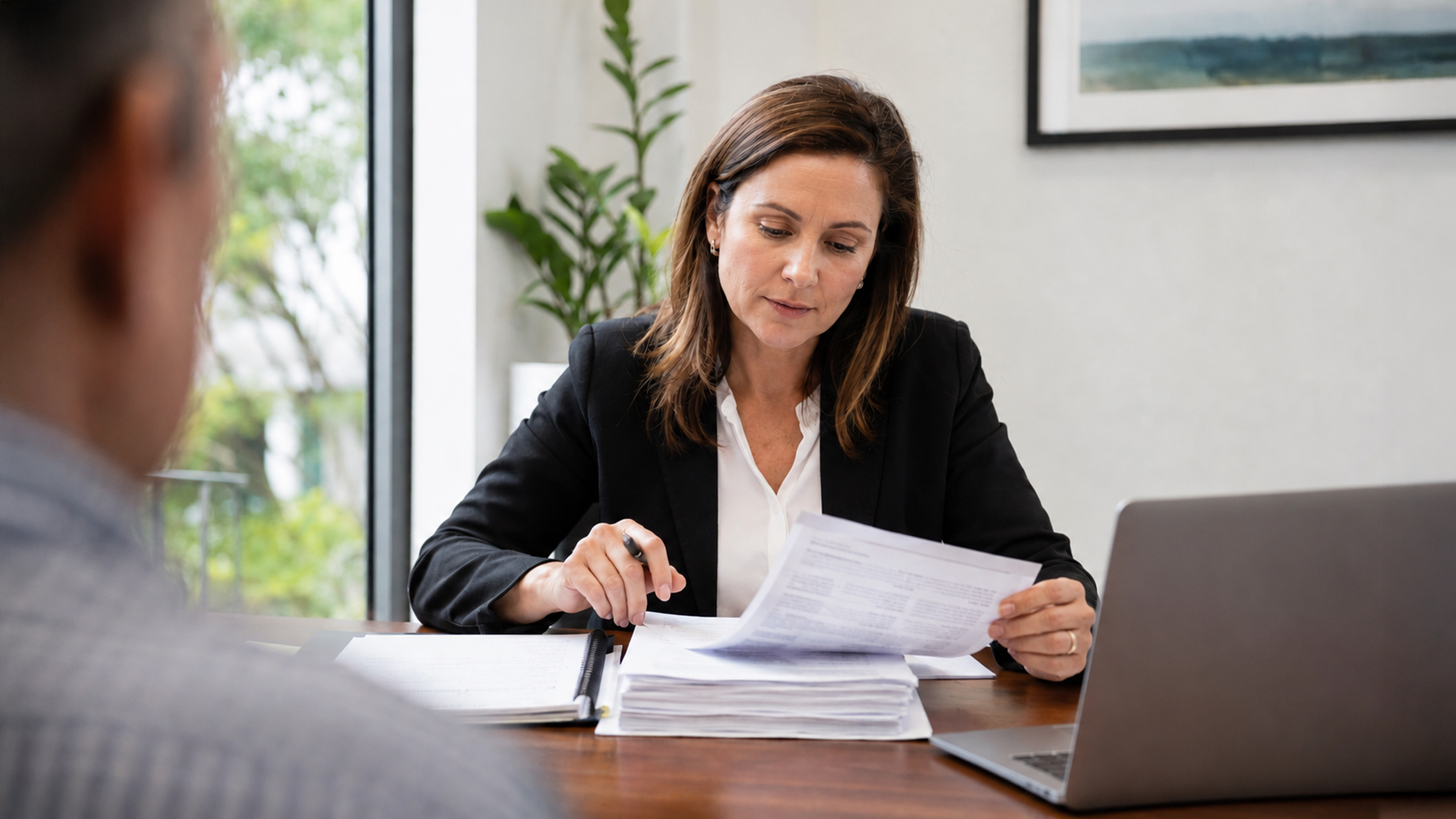Lawyer reviewing business and trust documents during a divorce property settlement.
