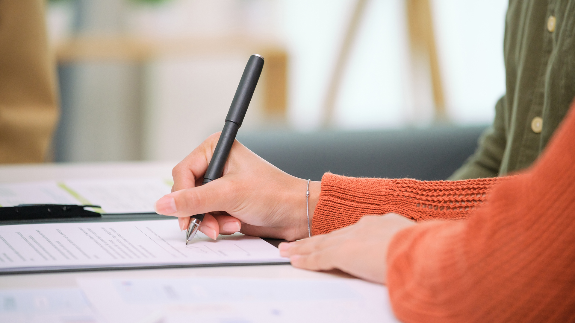 Parents signing documents to formalise parenting arrangements after separation