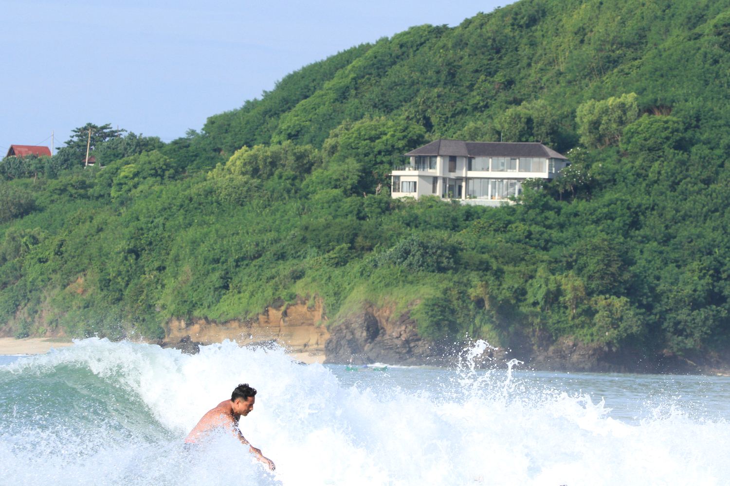 a long wave peeling below the villa