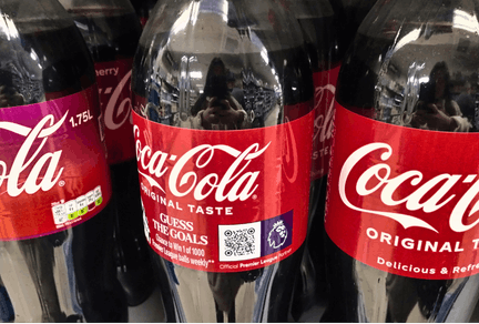 Promotional bottles of Coca-Cola on-shelf.