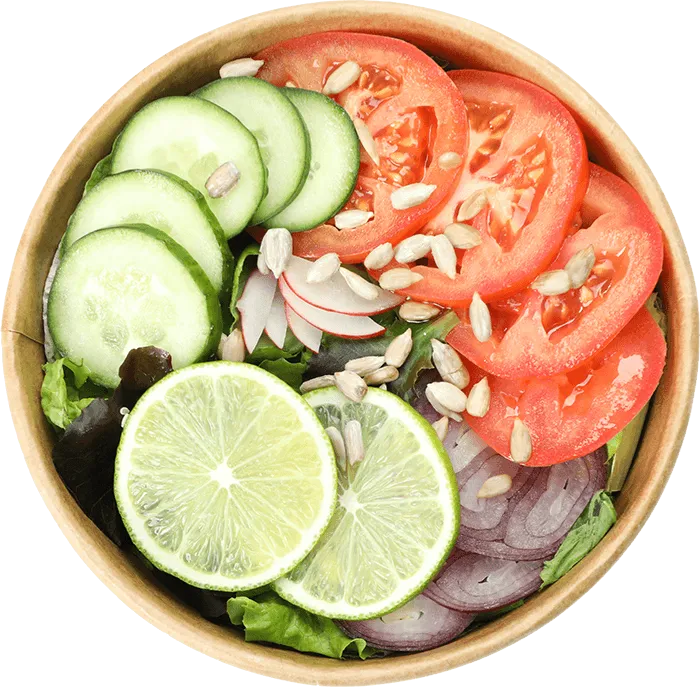 Salad bowl with sliced cucumber, tomato, red onion, radish, lime, mixed greens, and sunflower seeds.