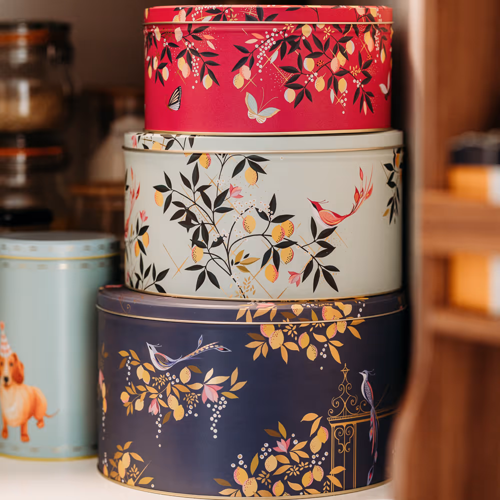 Stacked circular tins with floral and bird designs in red, white, and blue colors.