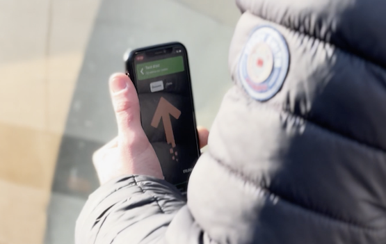 utilisateur avec son smartphone dans la main, écran avec solution de guidage