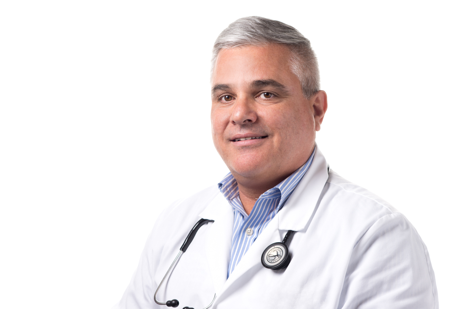 Dr. Manny Hernandez, M.D., a mature man with short gray hair and glasses, wearing a gray medical coat with a stethoscope and a striped tie.