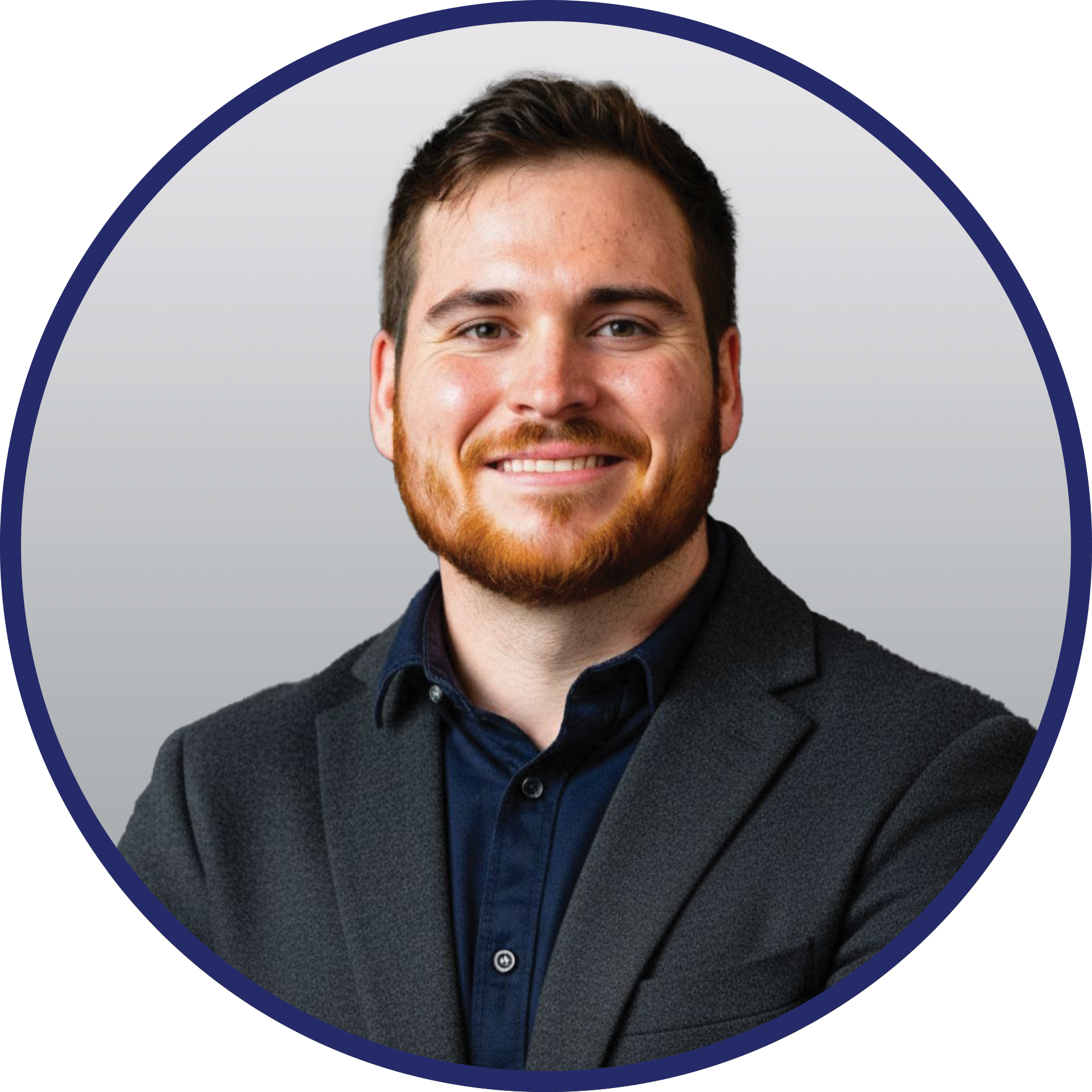 Headshot of Goran Jankobiv, a Caucasian man with short blonde hair, smiling broadly. He is wearing a navy blue blazer over a white shirt, set against a light background.