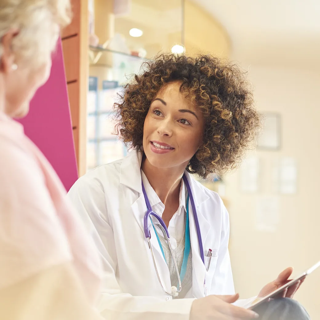 Family physician talking with an older patient in a primary care clinic