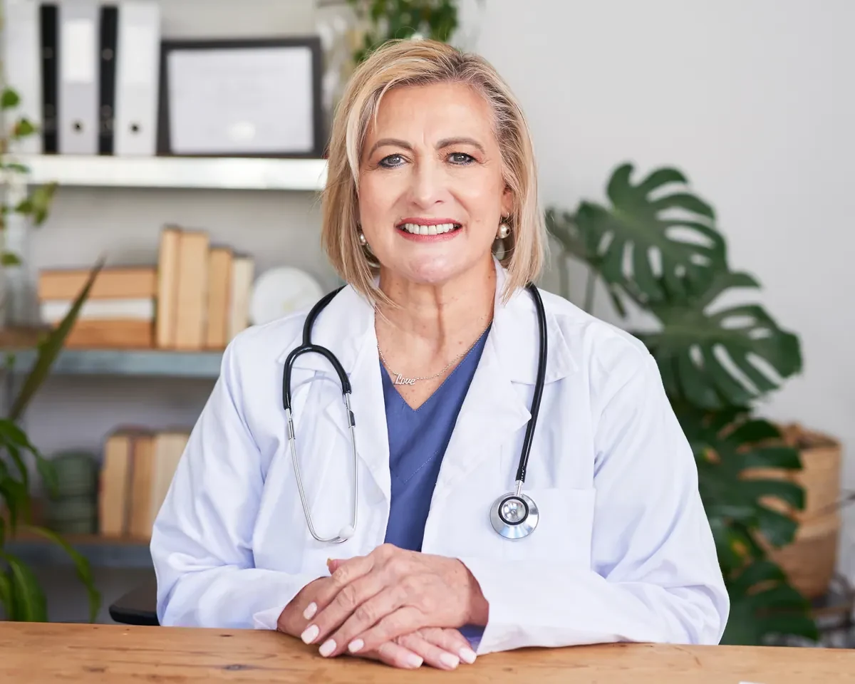 Smiling physician practice owner seated at her desk