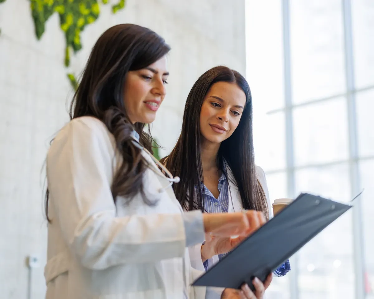 Physician and colleague reviewing documents together