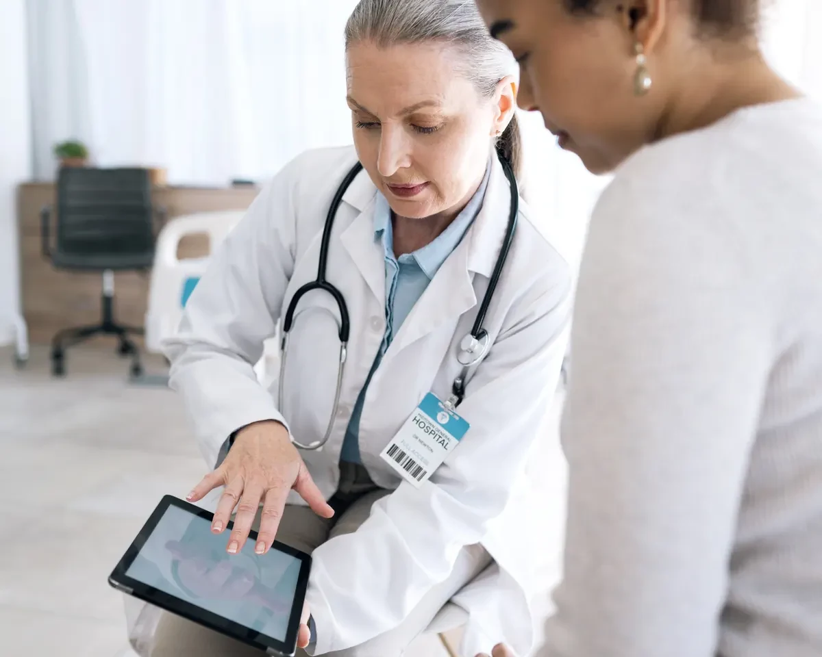 Physician reviewing information on a tablet with a patient