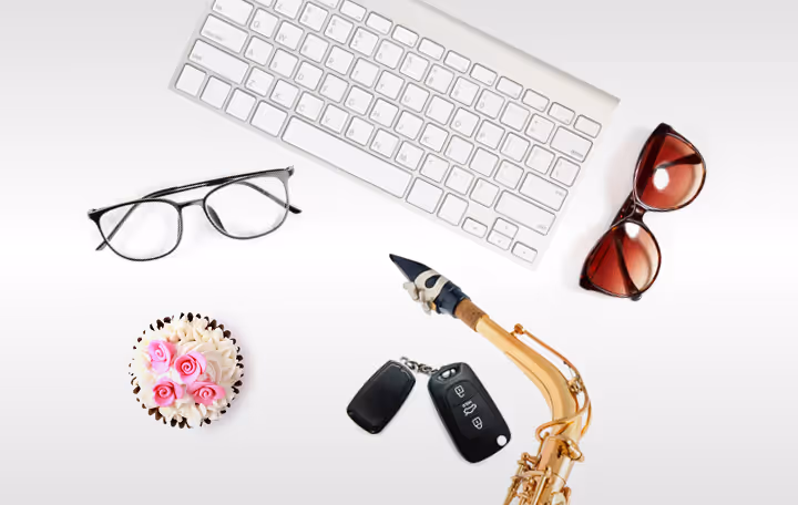 A computer keyboard, sunglasses, keys, and a bouquet of flowers