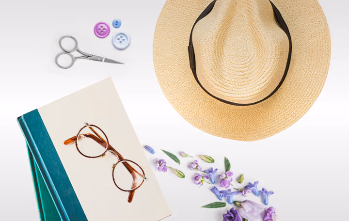 A hat, eyeglasses, a notepad, and a pair of scissors