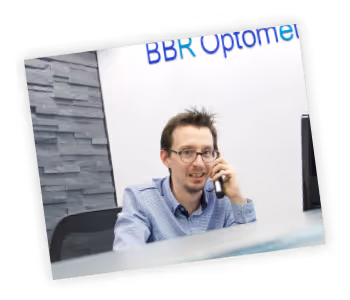 A man sitting at a desk talking on a cell phone