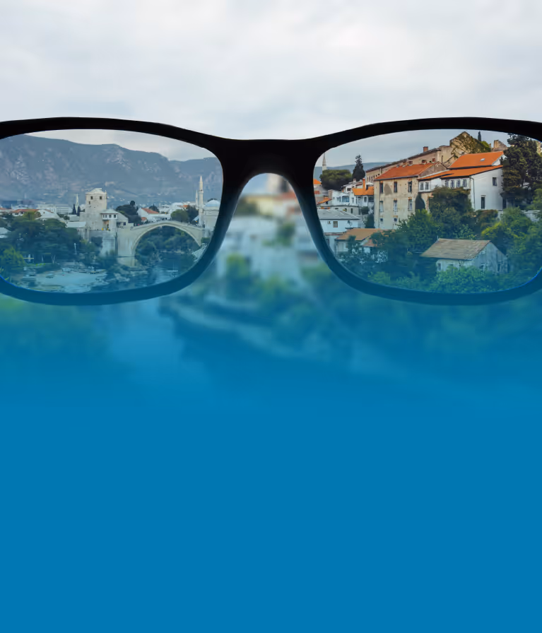 A pair of glasses with a reflection of a city in them