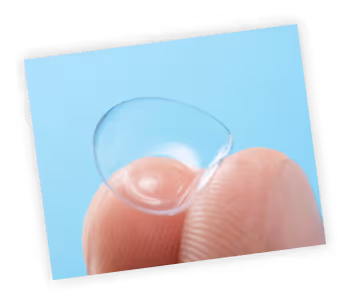 A hand holding a clear glass with a blue sky in the background
