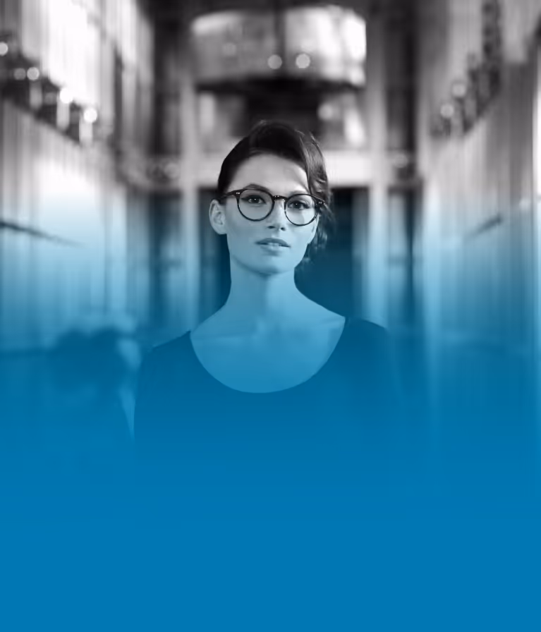 A woman wearing glasses standing in a hallway