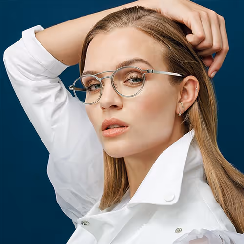 A woman wearing lindberg glasses and a white shirt