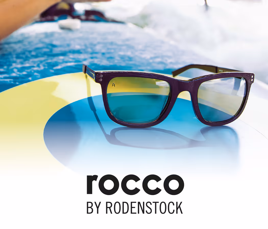 A pair of sunglasses sitting on top of a surfboard