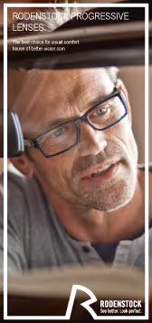 A man in glasses is looking out the window of a car