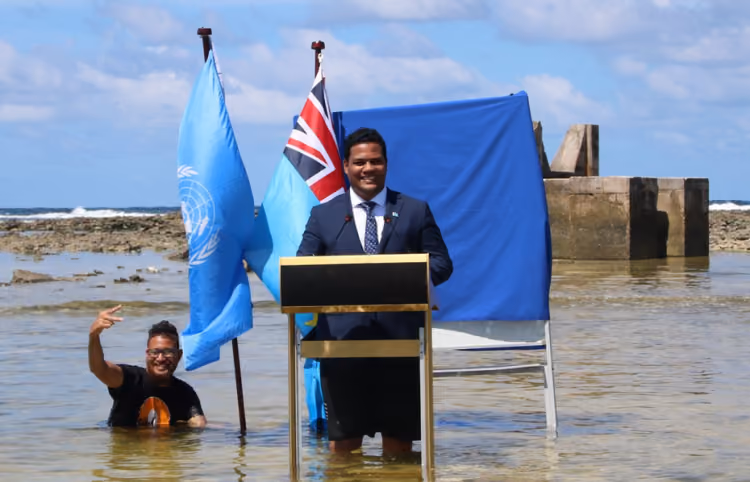 Tuvalu Minister Simon Kofe delivering a speech in knee-deep water for COP26