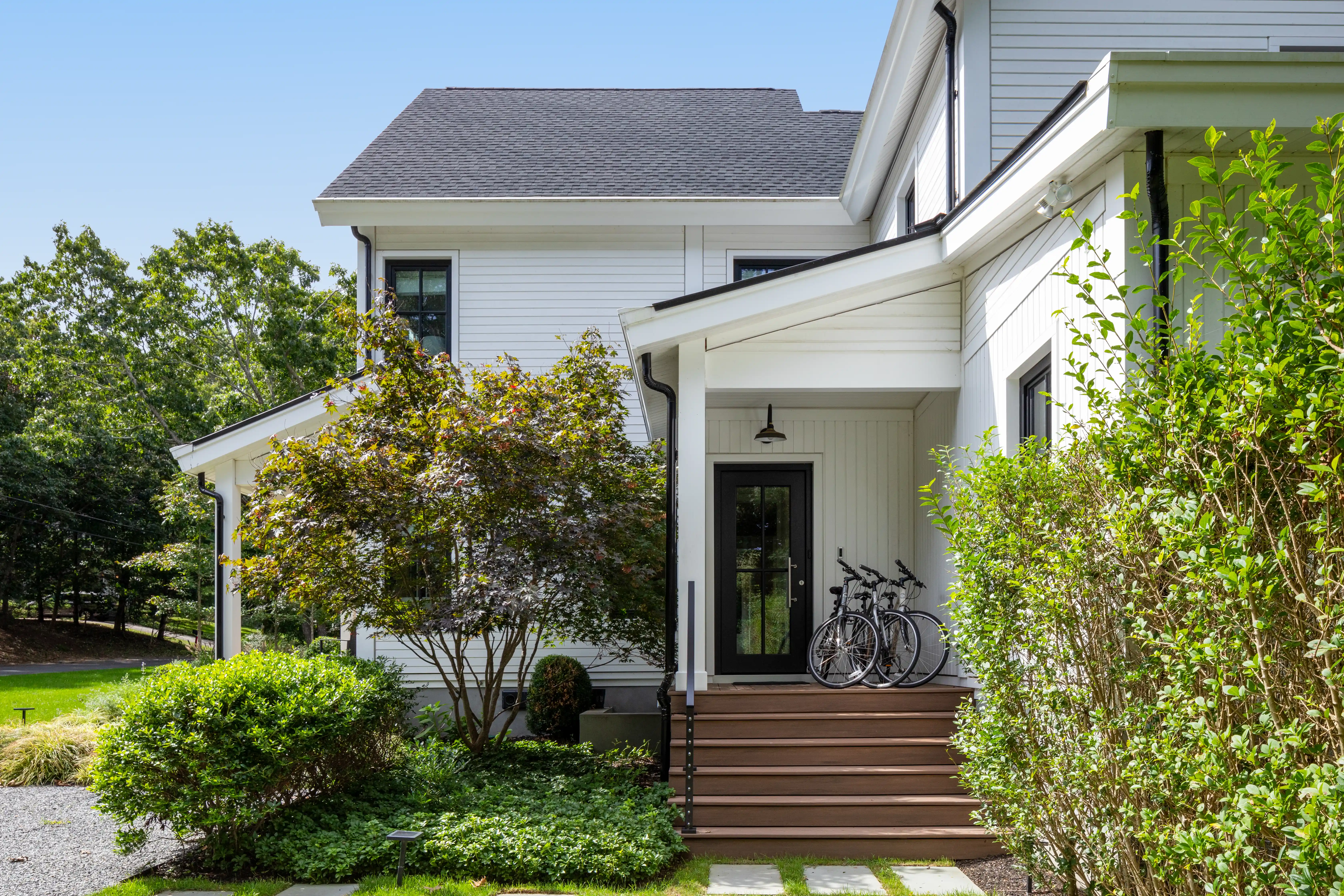 Modern white custom home exterior with landscaped front entrance