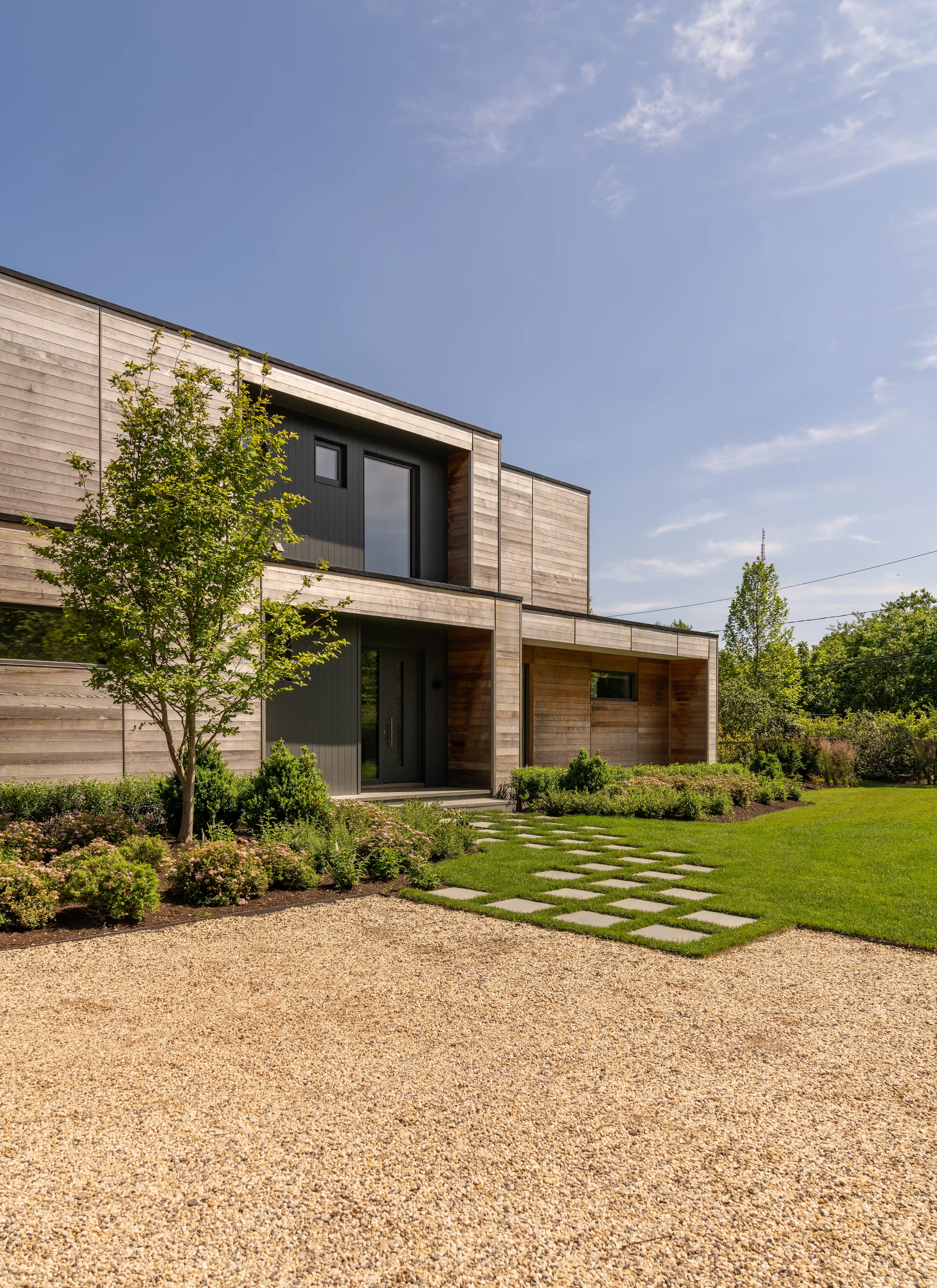 custom home with modern exterior design and landscaped entryway 