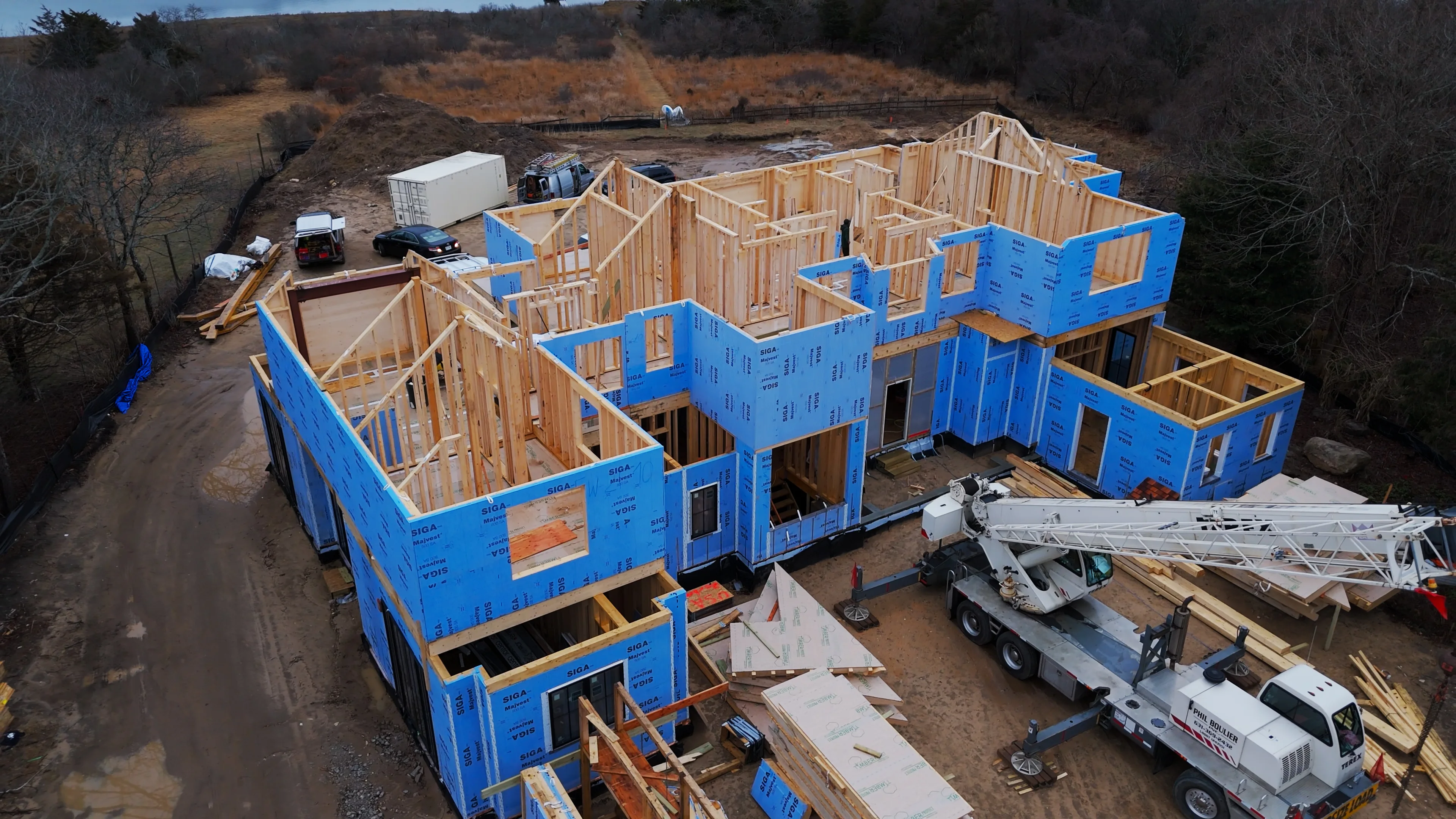 Large residential construction project with wood framing and crane installation