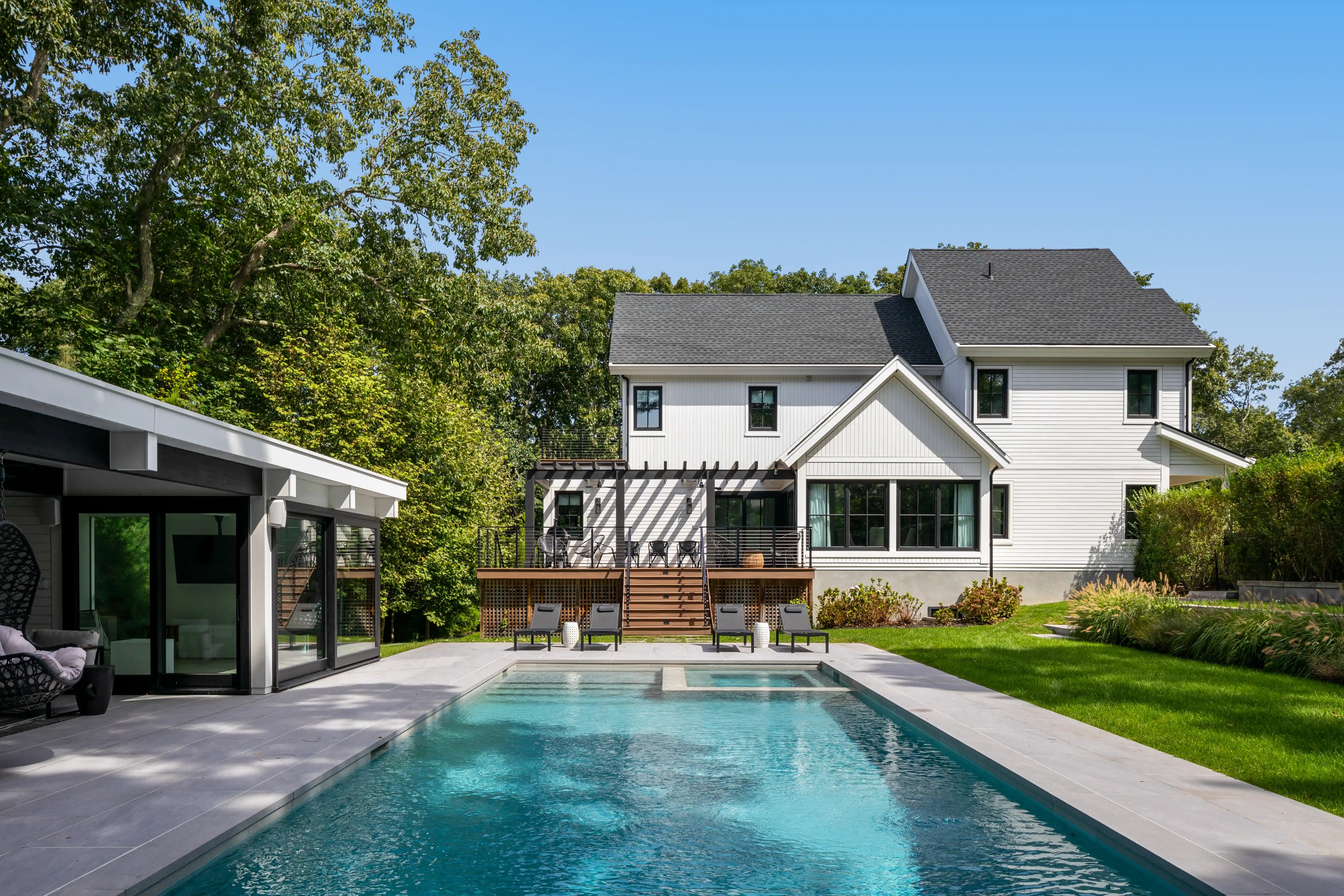 Luxury custom home backyard with swimming pool and elevated outdoor deck 