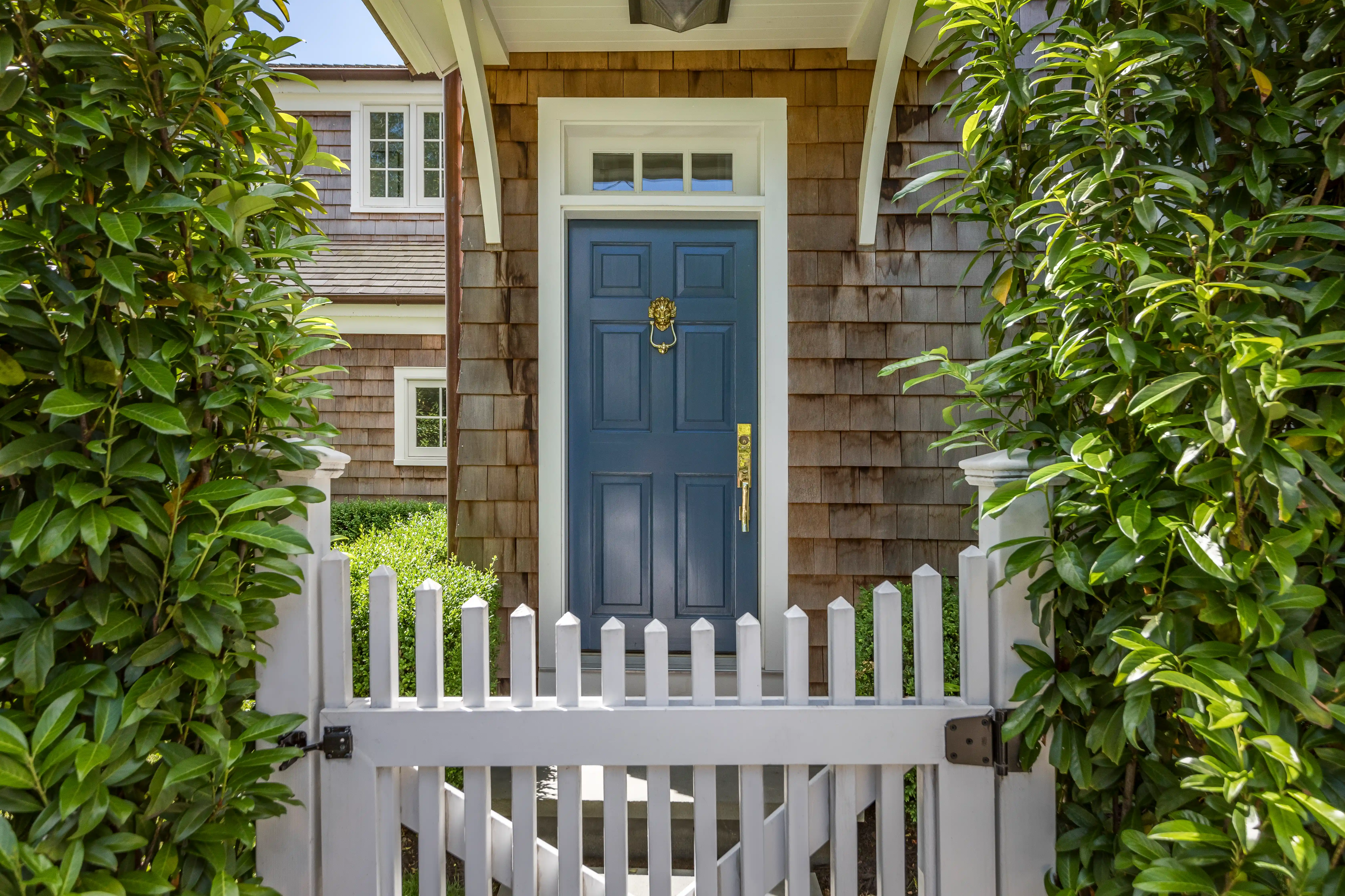 Custom luxury home entrance with blue front door and landscaped walkway 