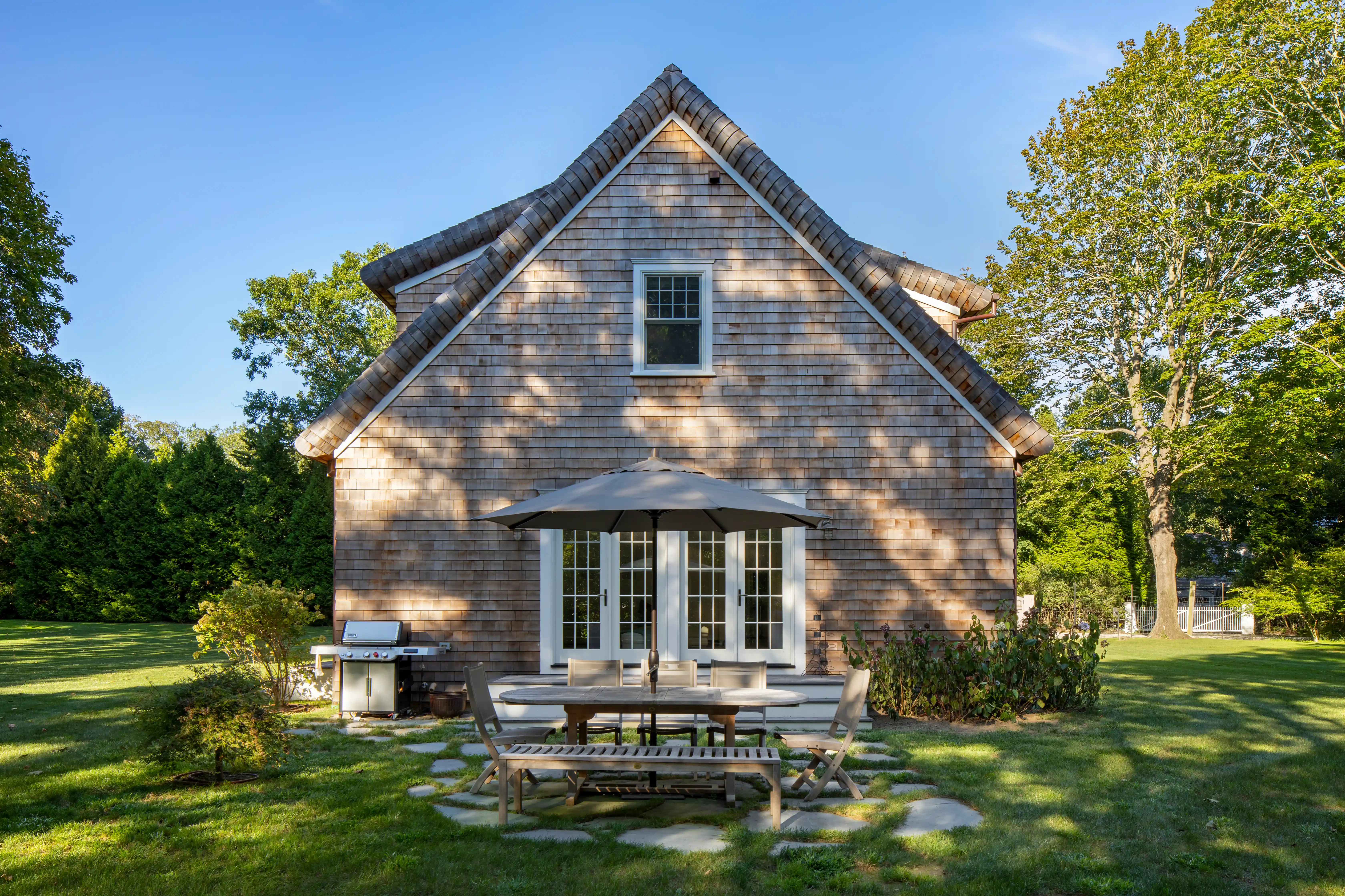 custom home addition with outdoor dining area and landscaped yard