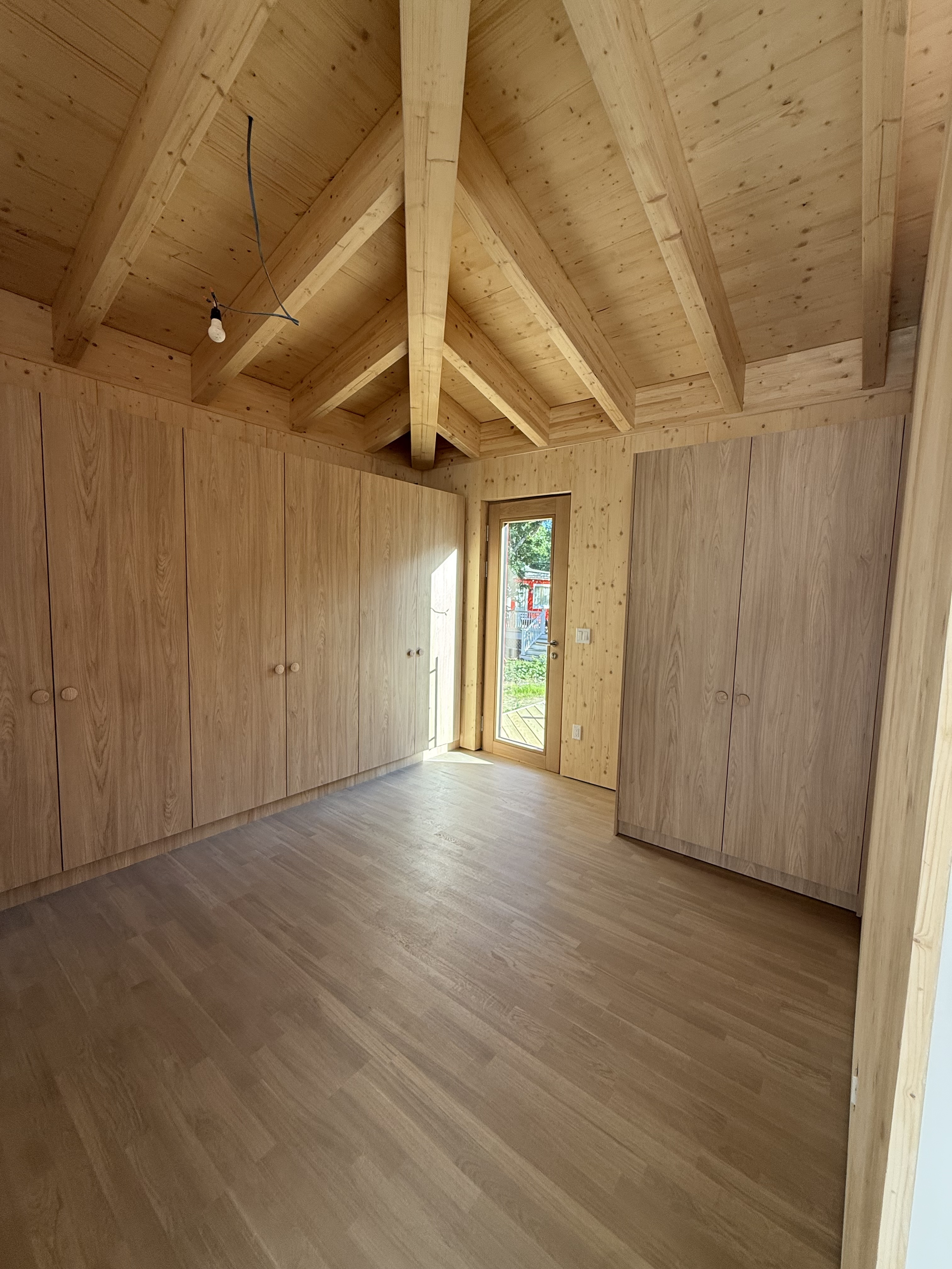 Wood-finished bedroom with integrated storage and natural lighting