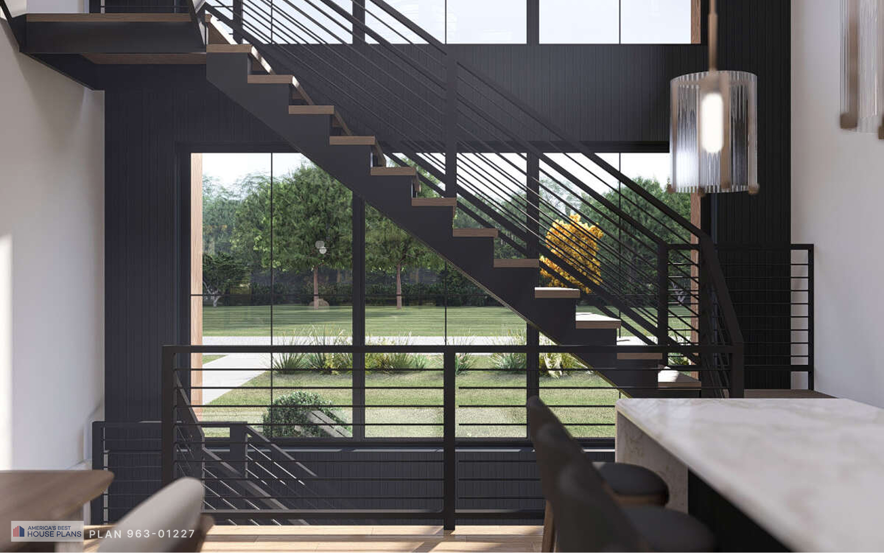 Modern staircase with black metal railing and floor-to-ceiling windows overlooking the landscape