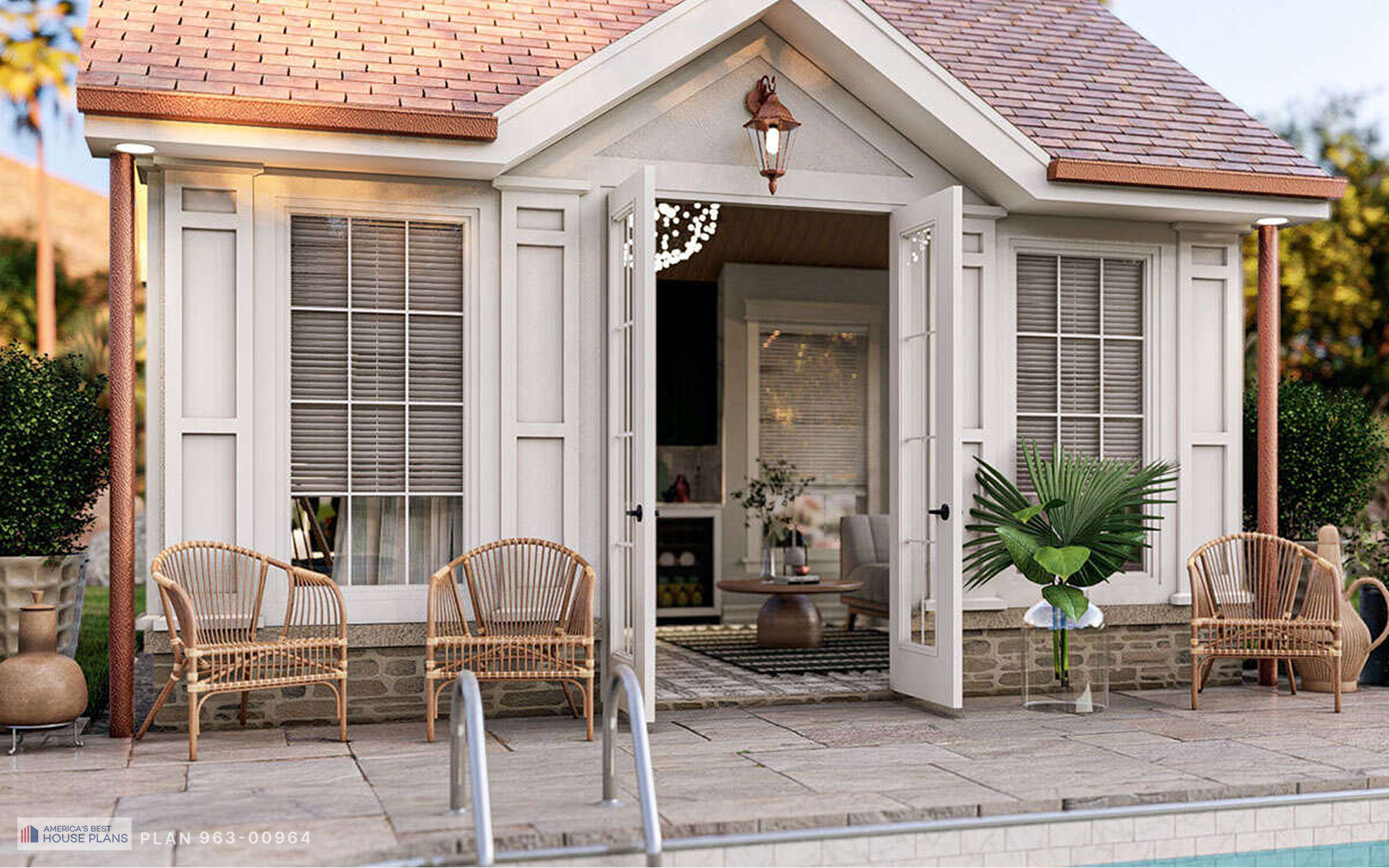 Cottage pool house with open French doors leading to a bright interior, poolside patio seating, and decorative landscaping