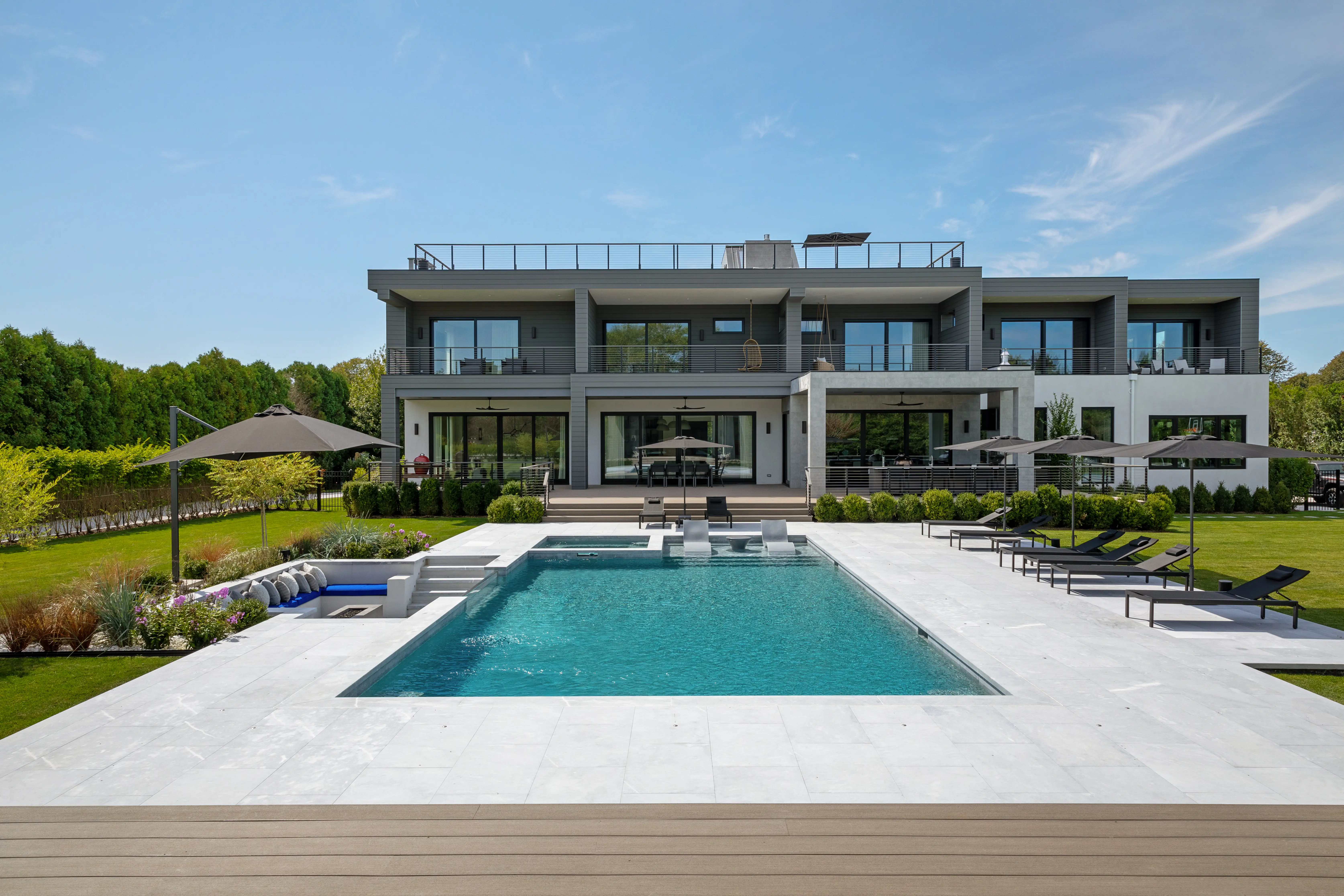 Luxury modern waterfront mansion with an expansive swimming pool, rooftop terrace, landscaped backyard