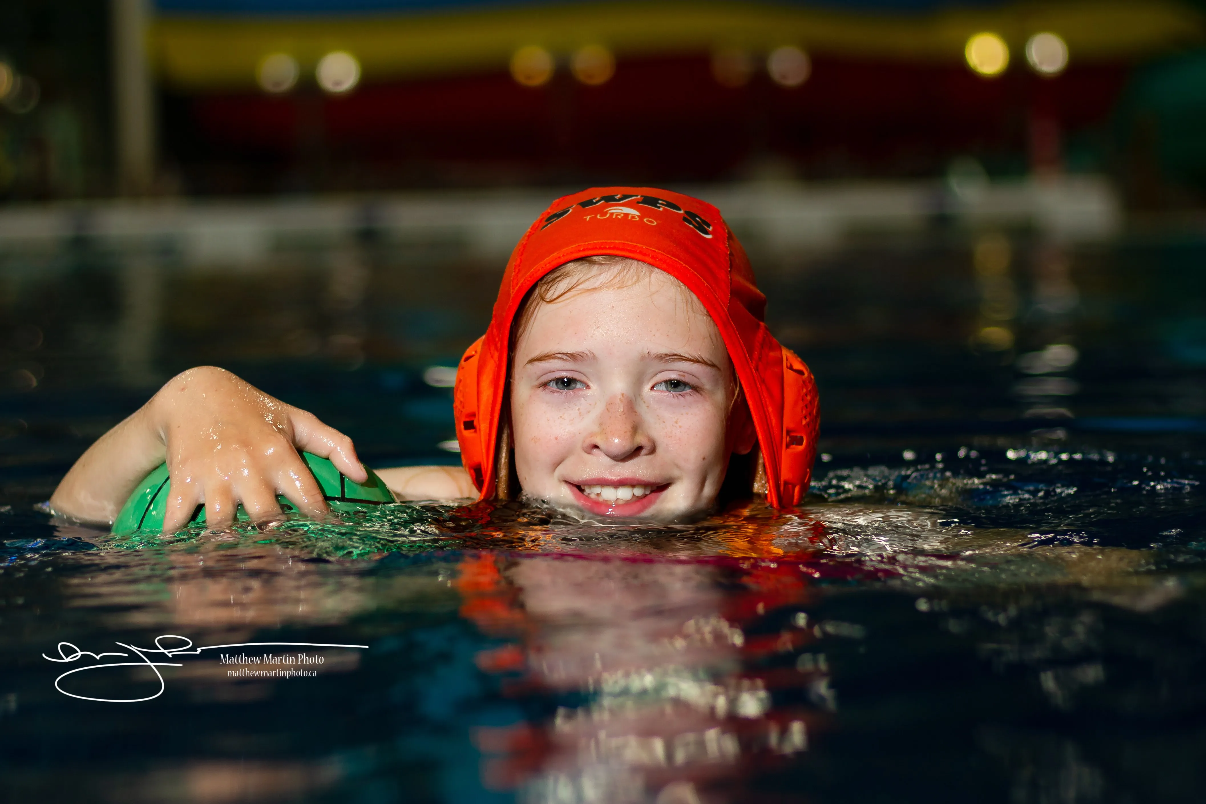 Smiling young player in an orange cap at the water's surface