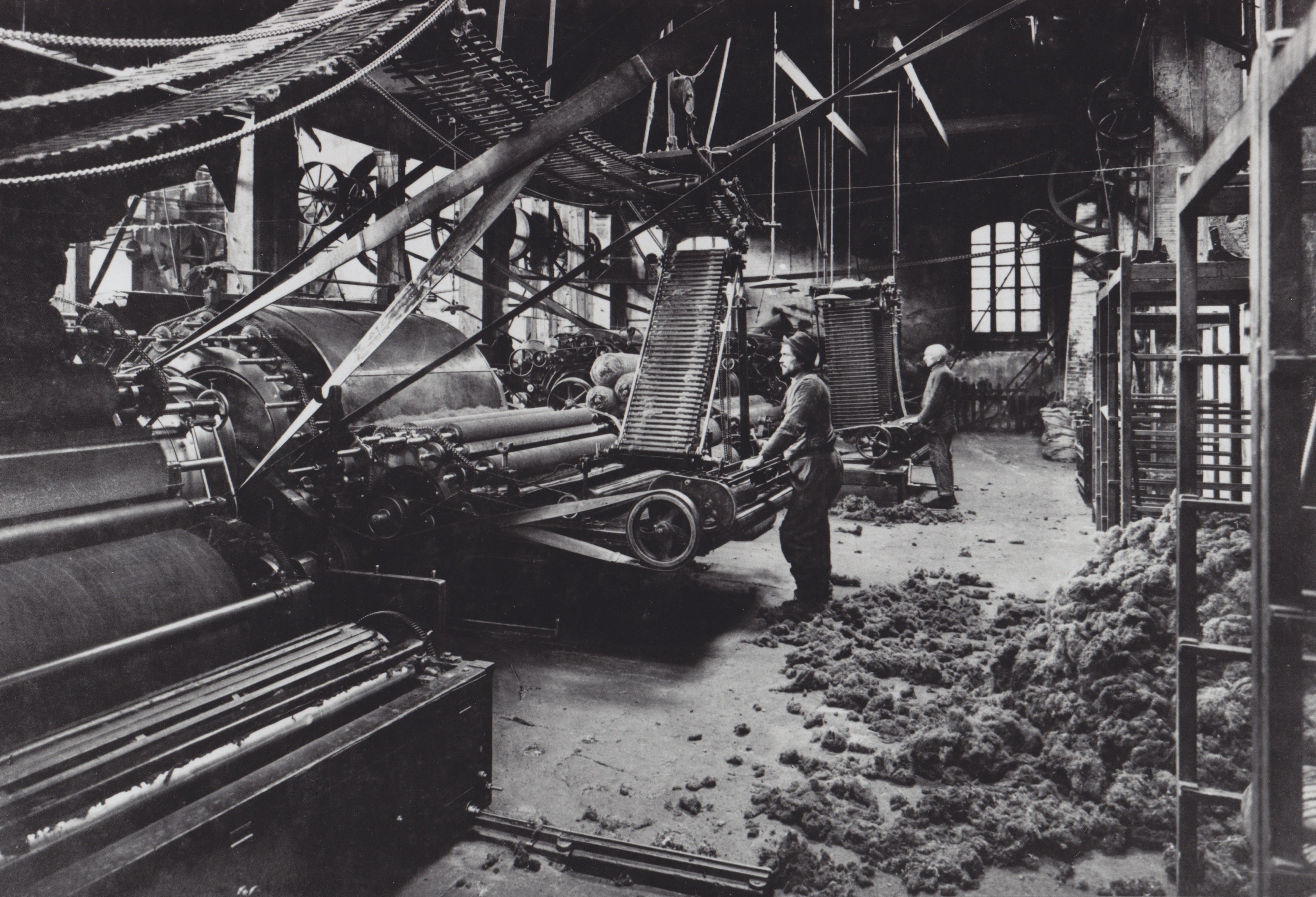 A back and white picture of the old wool industry in Prato, displaying two man working.