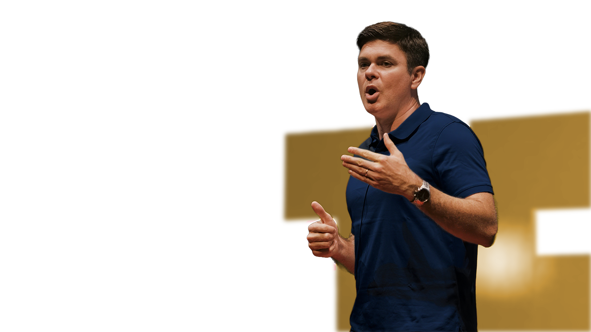 Man in navy blue polo shirt speaking animatedly with hand gestures.