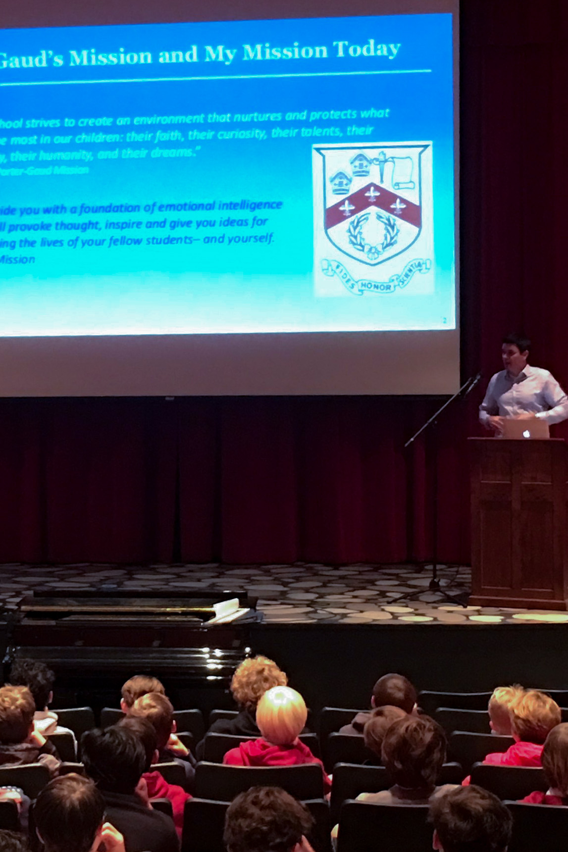 Chris D. Connors standing at a podium speaking to an audience of students with a slideshow.