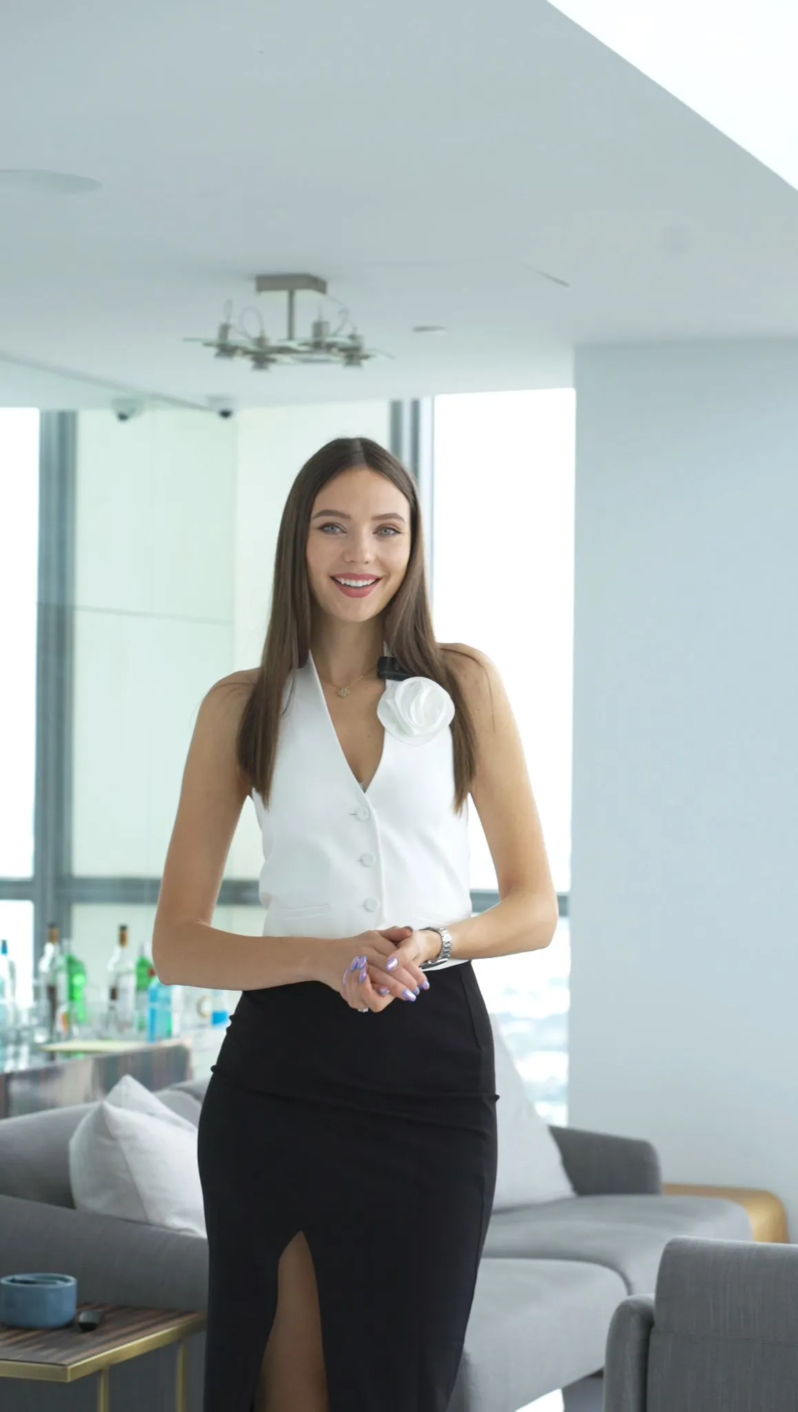 Real estate agent in white standing in a modern high-rise condo