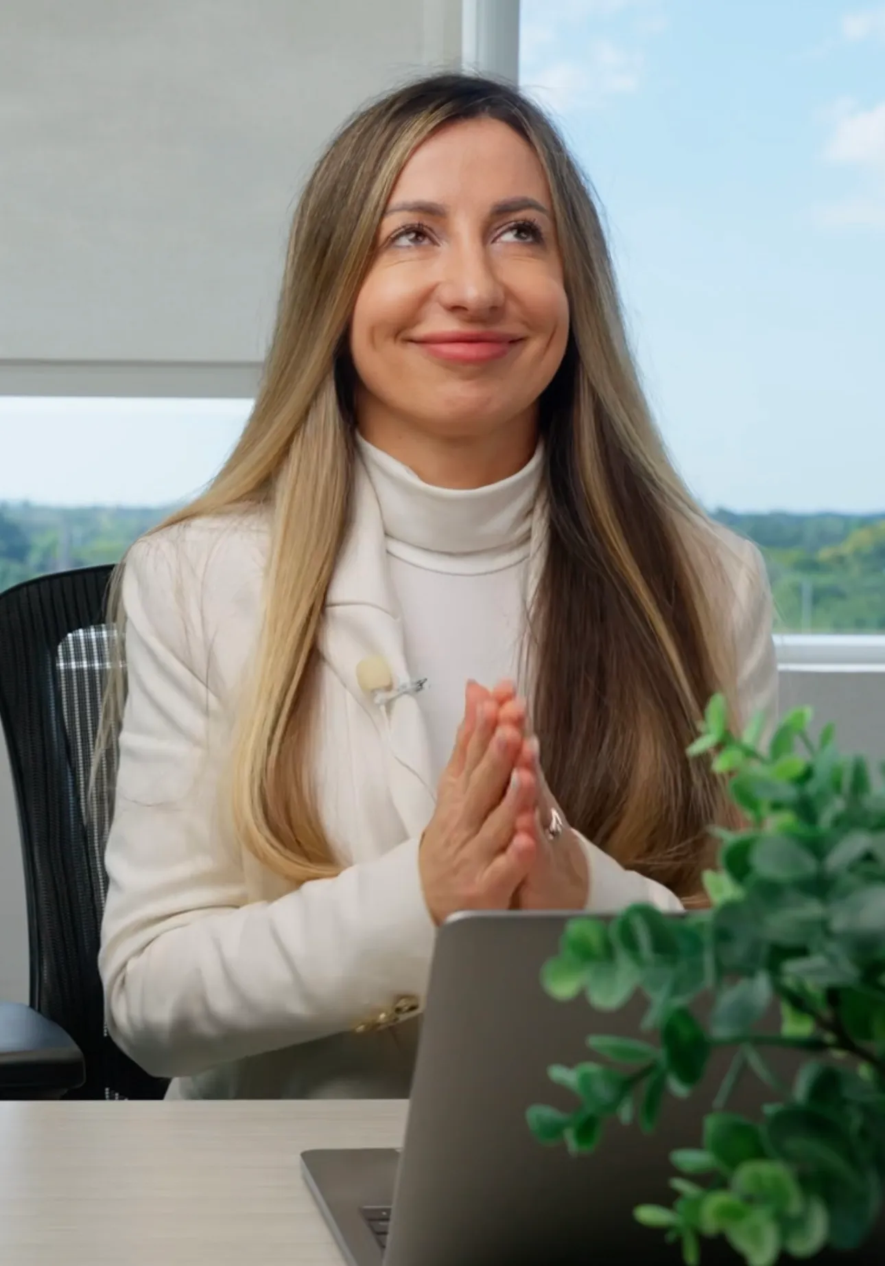 Smiling businesswoman at her desk during a corporate interview shoot
