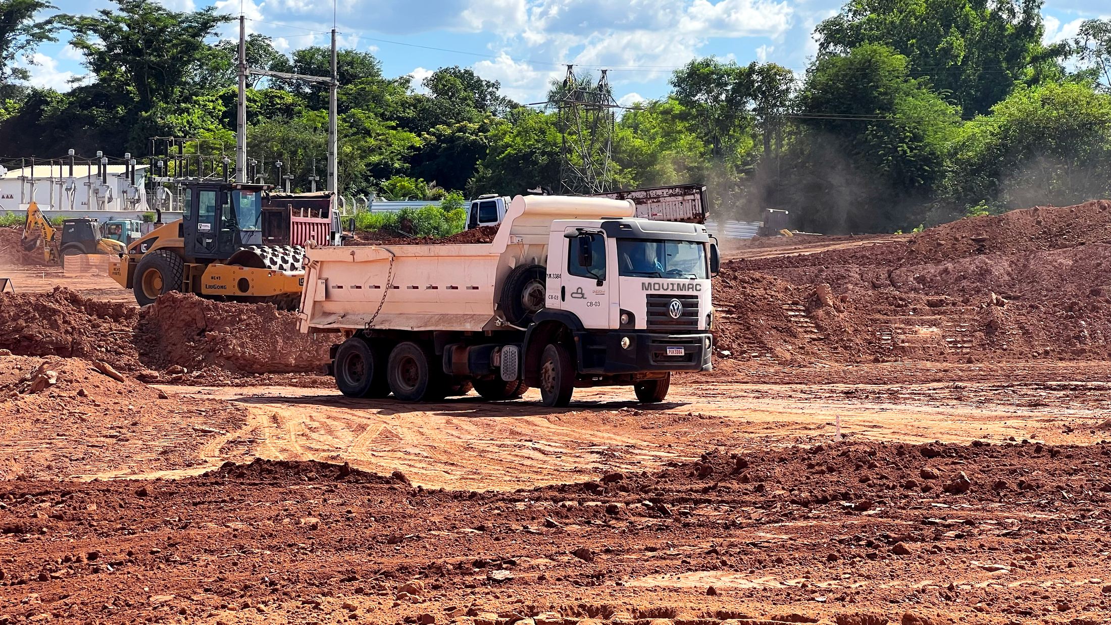 Caminhão bascul ante e rolo compactador em frente de terraplanagem - MSE Engenharia