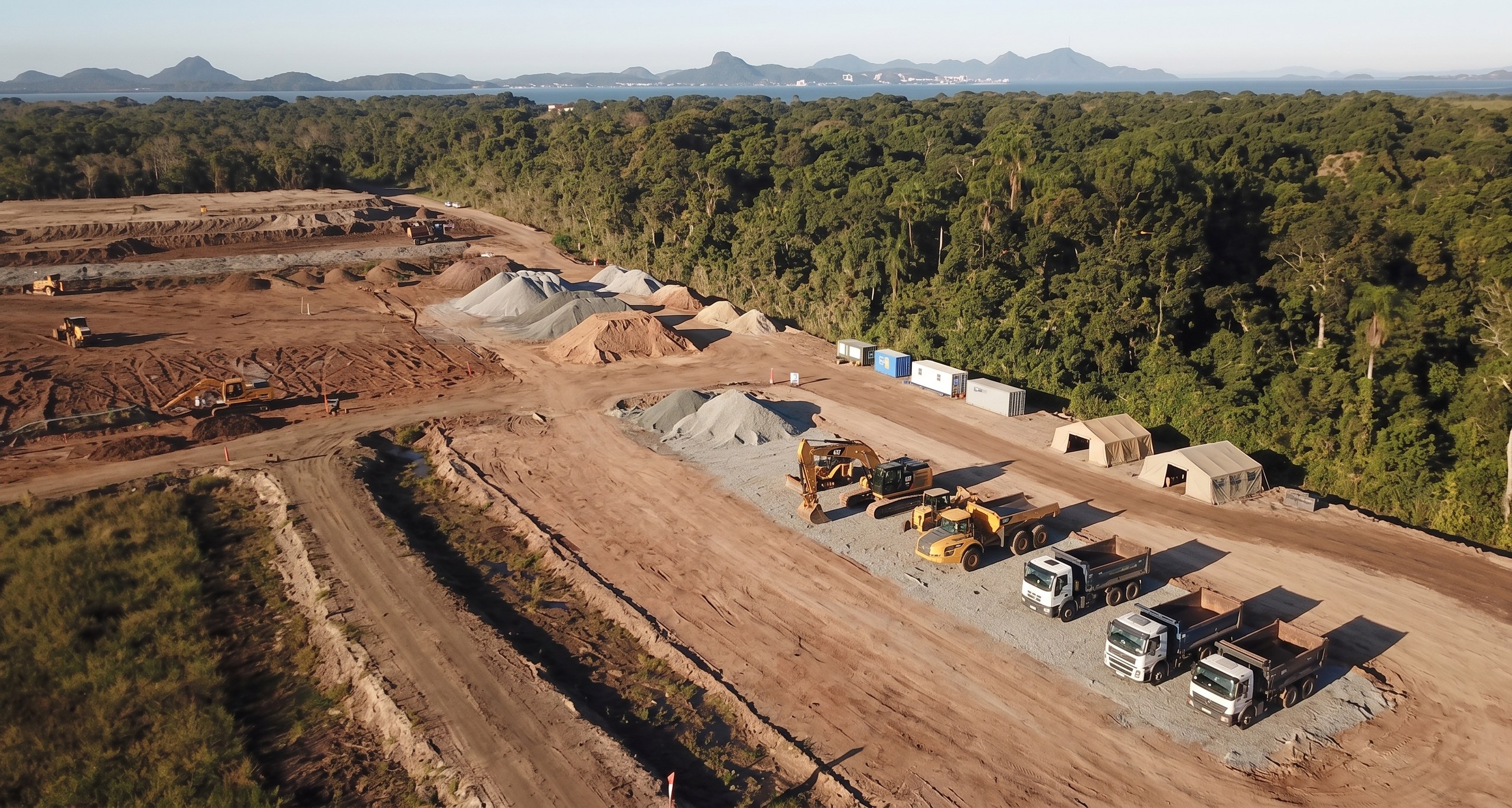 Vista aérea do canteiro de terraplanagem com pilhas de brita e frota mobilizada - MSE Engenharia