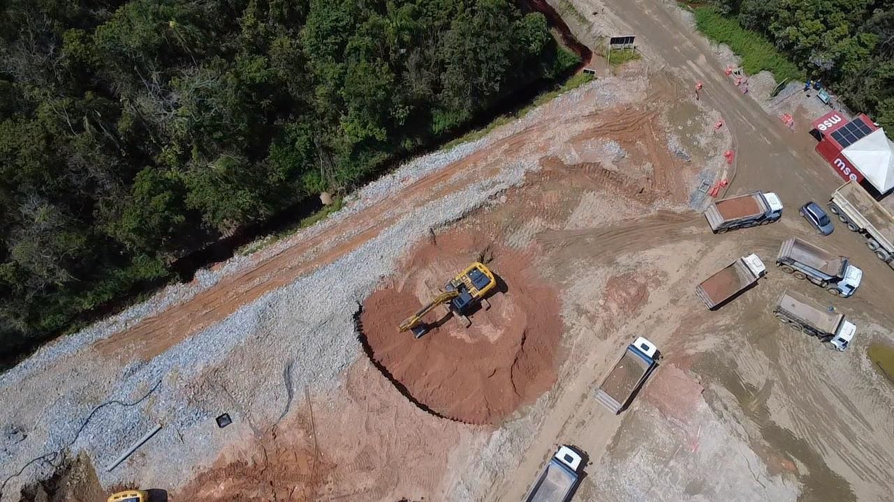 Escavadeira e caminhões basculantes em frente de descarga de material - MSE Engenharia