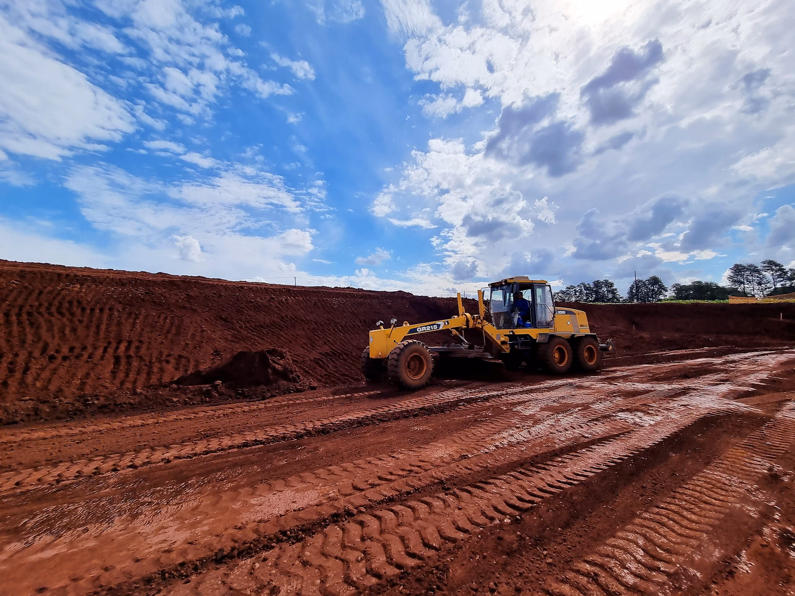 Motoniveladora regularizando platô em solo de terra roxa - MSE Engenharia