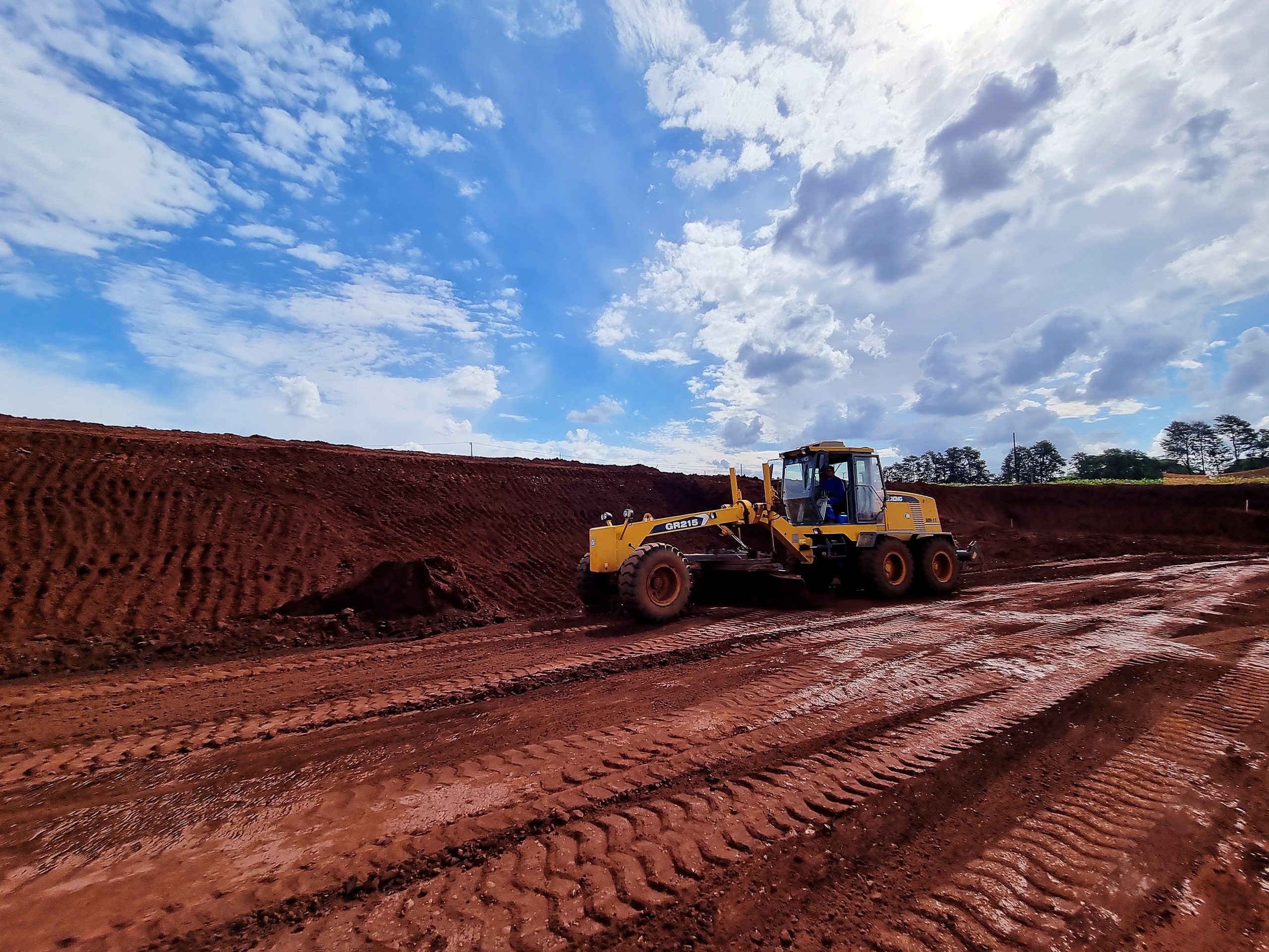 Motoniveladora regularizando platô em solo de terra roxa - MSE Engenharia